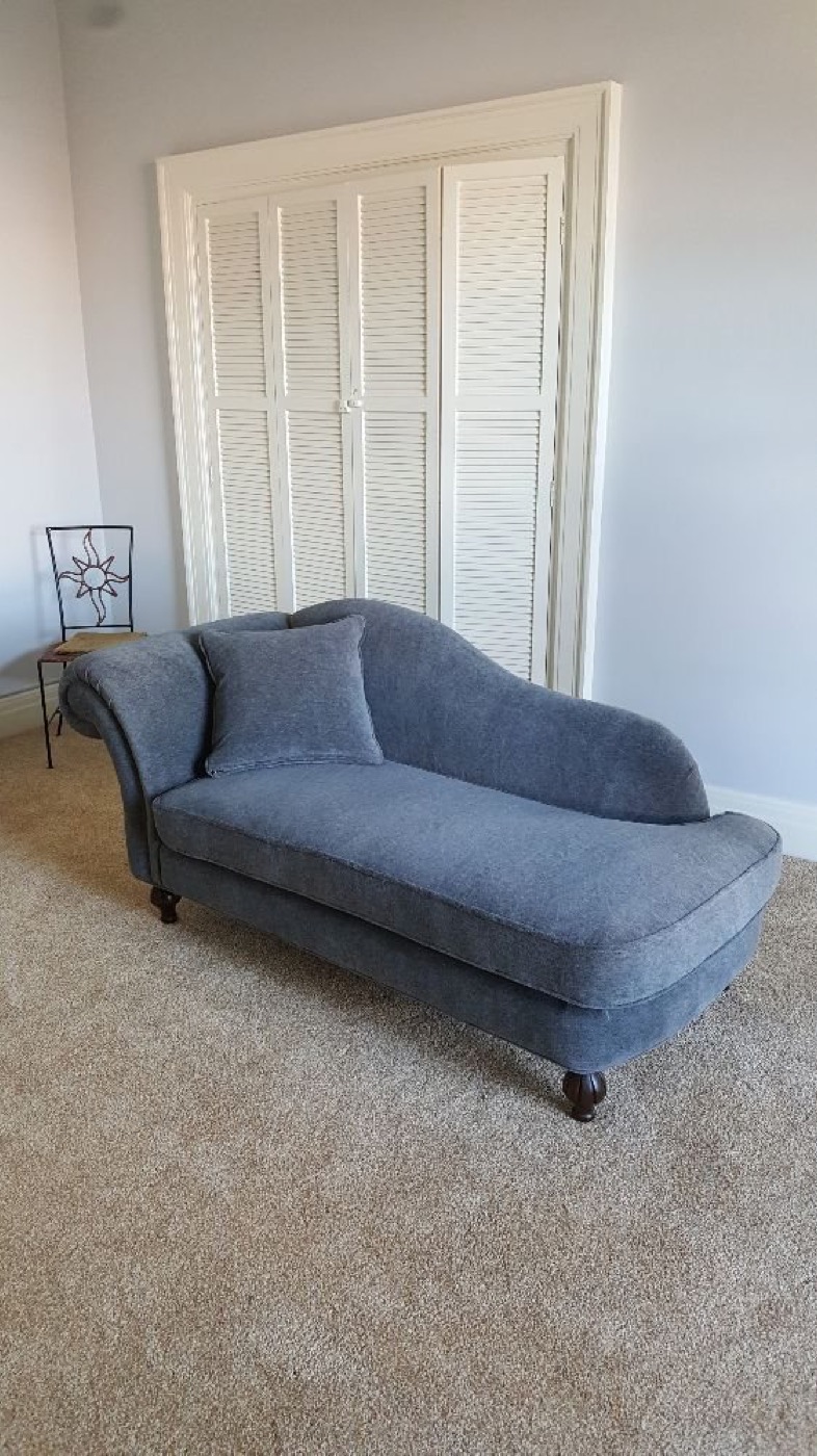 A blue chaise longue reupholstered in a soft woven fabric.