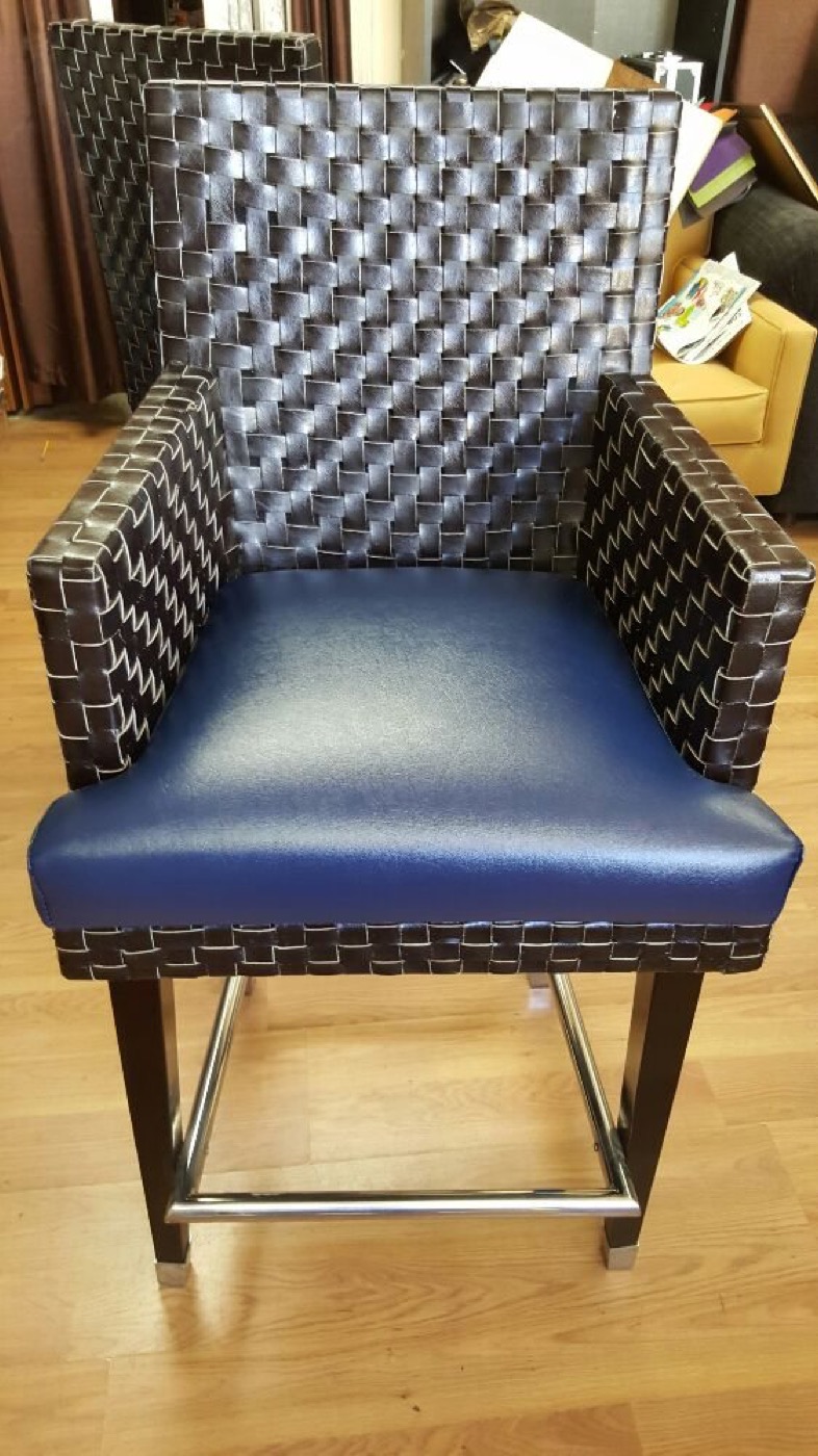A modern chair with a navy leather seat and a woven leather back.