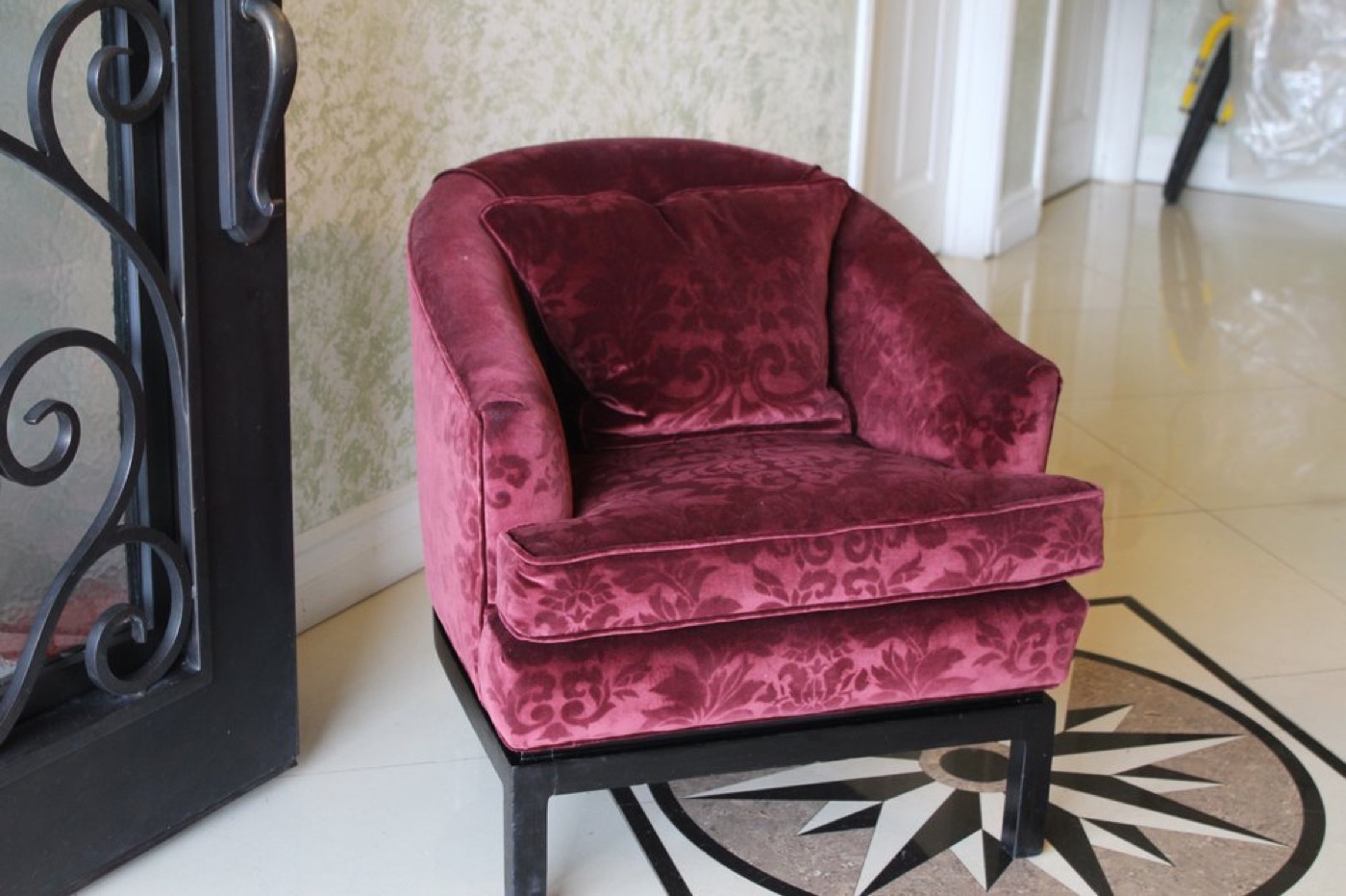 A barrel chair reupholstered in wine-coloured velvet.